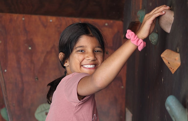 camp girl on climbing wall
